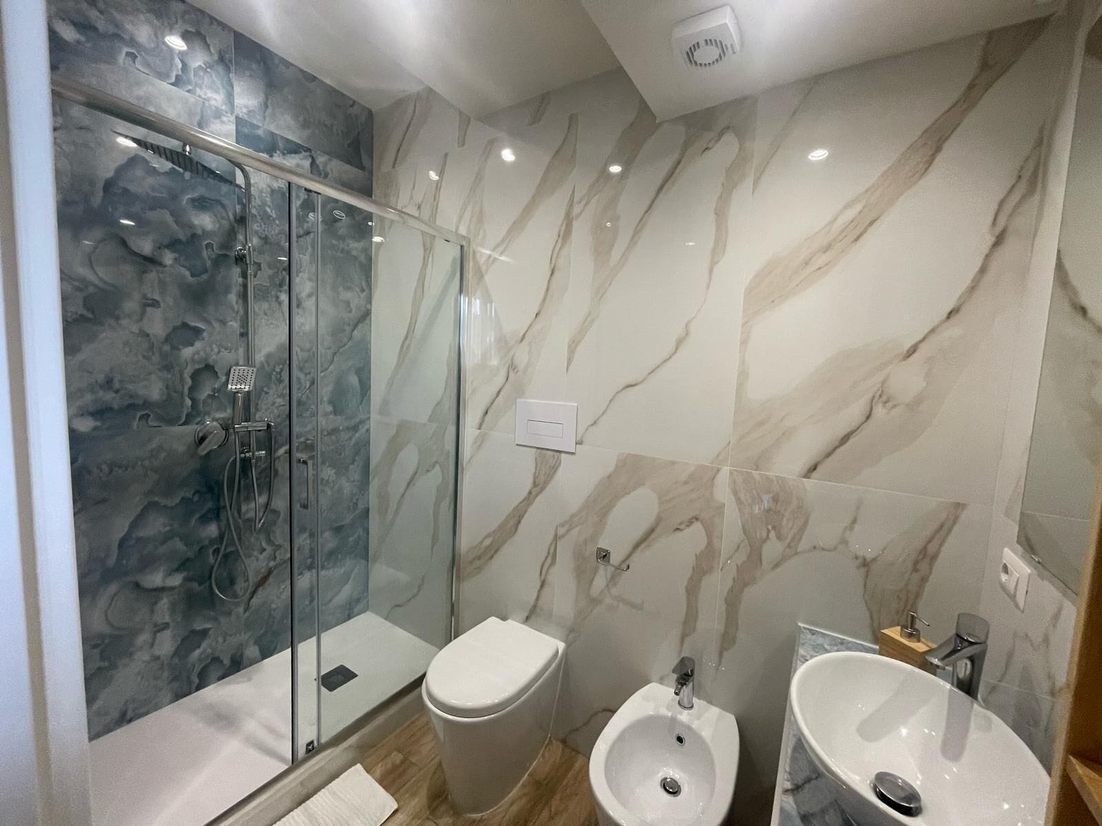Une salle de bain moderne avec une douche à parois de verre, des toilettes, un bidet et un lavabo.