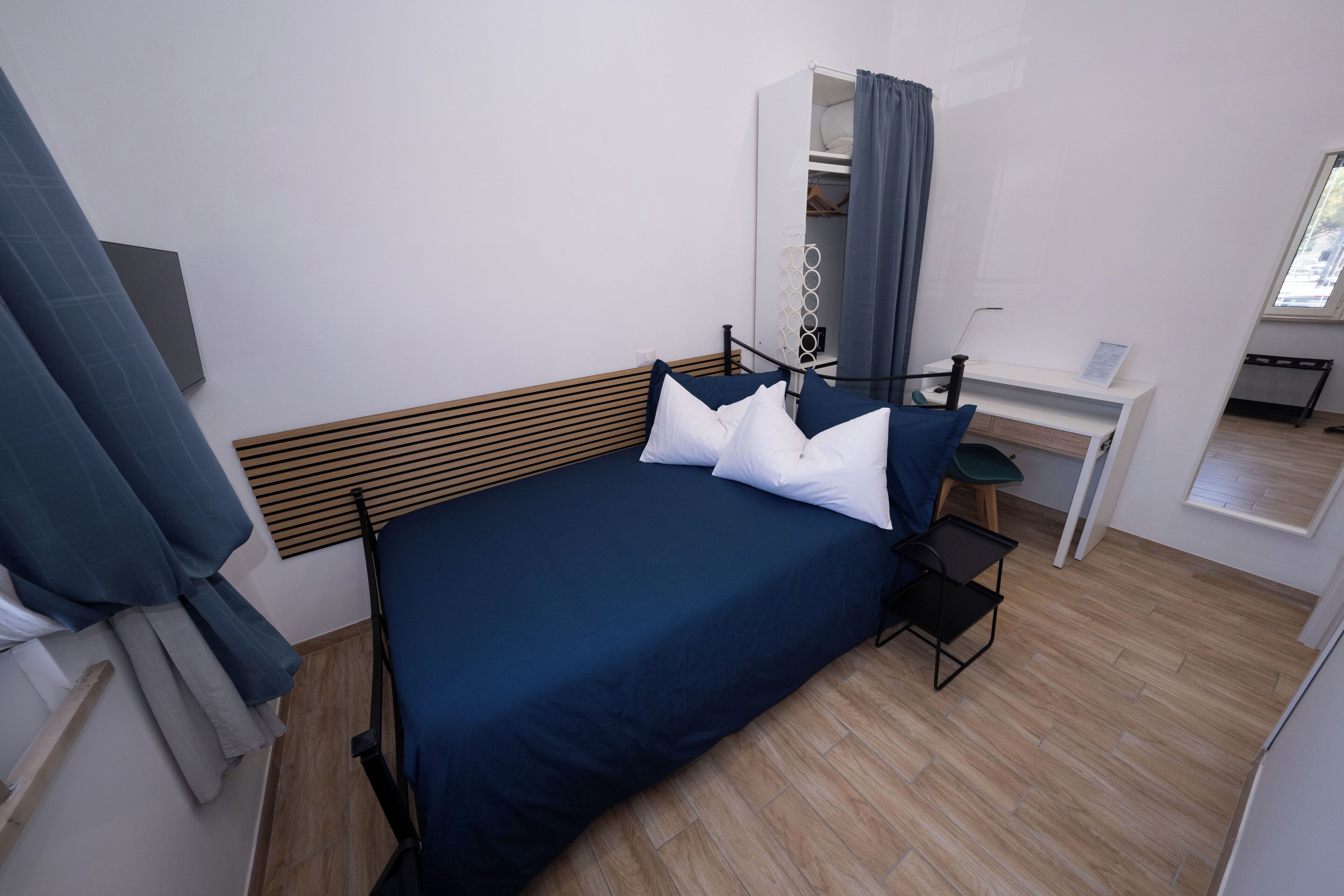 Une chambre à coucher comprenant un lit, un bureau, une chaise et une armoire.