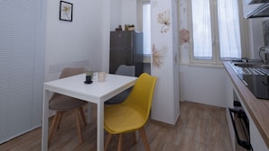 A compact kitchen with a dining area, a refrigerator, and a sink. - Partesia  (Naples)