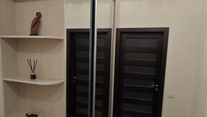A room with a mirrored wardrobe, a wooden floor, and a door with a handle. - Cozy 2-Bedroom Apartment BIG Klaipeda (Klaipėda)