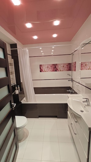 Ein modernes Badezimmer mit einer Badewanne, einer Toilette und einem Waschbecken.