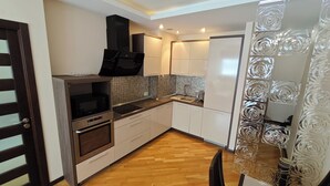 A compact kitchen with a microwave, oven, and sink. - Cozy 2-Bedroom Apartment BIG Klaipeda (Klaip ėda)