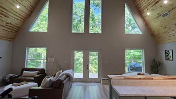 Un loft spacieux avec de hauts plafonds, de grandes fenêtres, un coin salon confortable et une cuisine dotée d’un plan de travail en marbre.