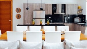 A modern kitchen with a central island, white chairs, and a wooden dining table. - Lifestyle Holidays Vacation Club (Puerto Plata)