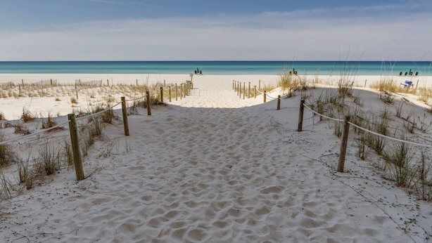 A sandy beach path leading to the ocean with a rope barrier and wooden posts. - Beachfront PCB 2BR Condo w Pools, Tennis & Gulf Views + Free Attraction Tix! (Panama City Beach)