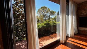 Ein Zimmer mit großem Fenster, Steinwand und Fliesenboden.