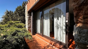 Un edificio moderno con grandes puertas correderas de vidrio, fachada de piedra y un camino de ladrillo que conduce a la entrada.