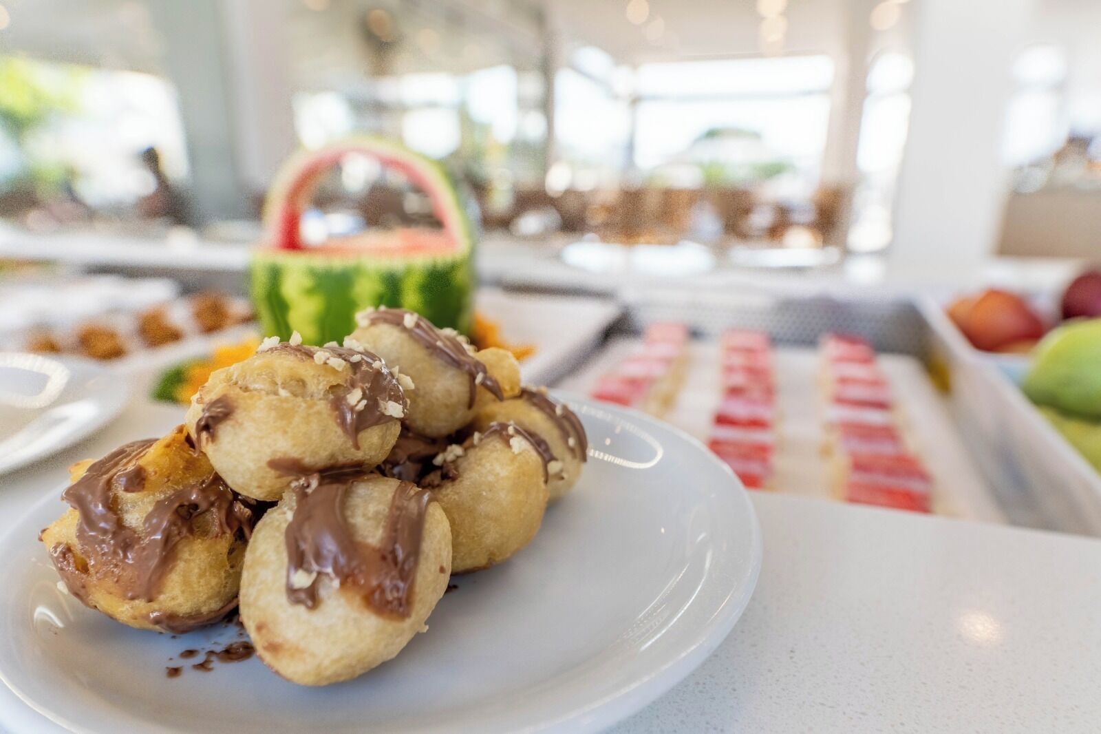 A plate of chocolate-covered pastries on a table.