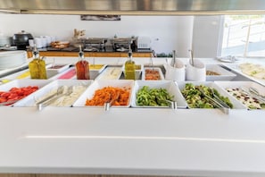 A buffet with various food items and condiments.