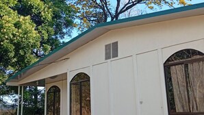 Un edificio con techo curvo, ventanas arqueadas y un porche cubierto.