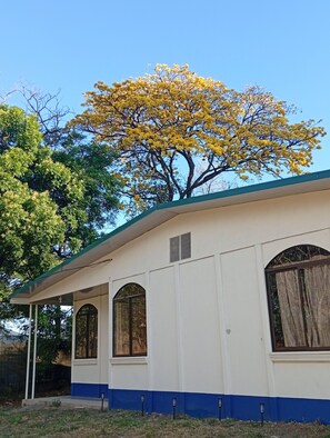 A building with a curved roof, arched windows, and a covered porch. - Auralivingcr (La Garita)