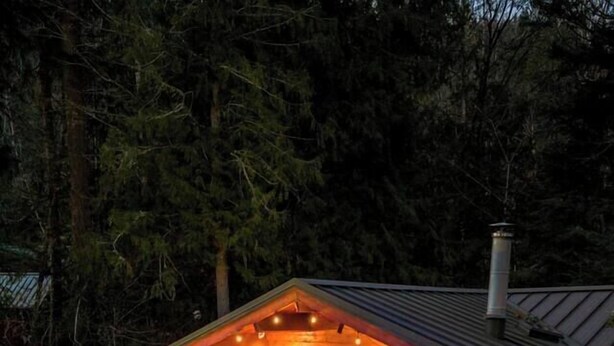 Ein gemütliches Blockhaus mit Whirlpool, Sitzgelegenheit im Freien und Kaminofen.