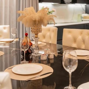 A dining table set with white plates, cutlery, and a glass of water. - Luna Casa Villa D7 with 9 bedrooms (Quan bay)
