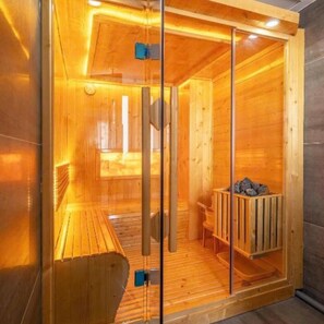 A sauna room with wooden walls and a glass door, a bench, and a bench seat. - Luna Casa Villa D7 with 9 bedrooms (Quan bay)