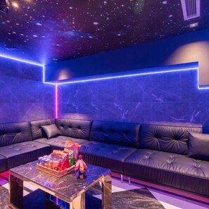 A modern lounge with a starry ceiling, a black leather sofa, and a marble coffee table with snacks. - Luna Casa Villa D7 with 9 bedrooms (Quan bay)