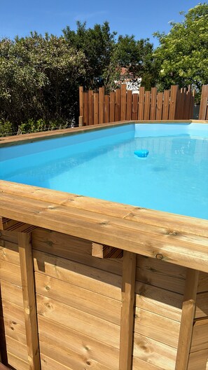 A wooden deck with a swimming pool.