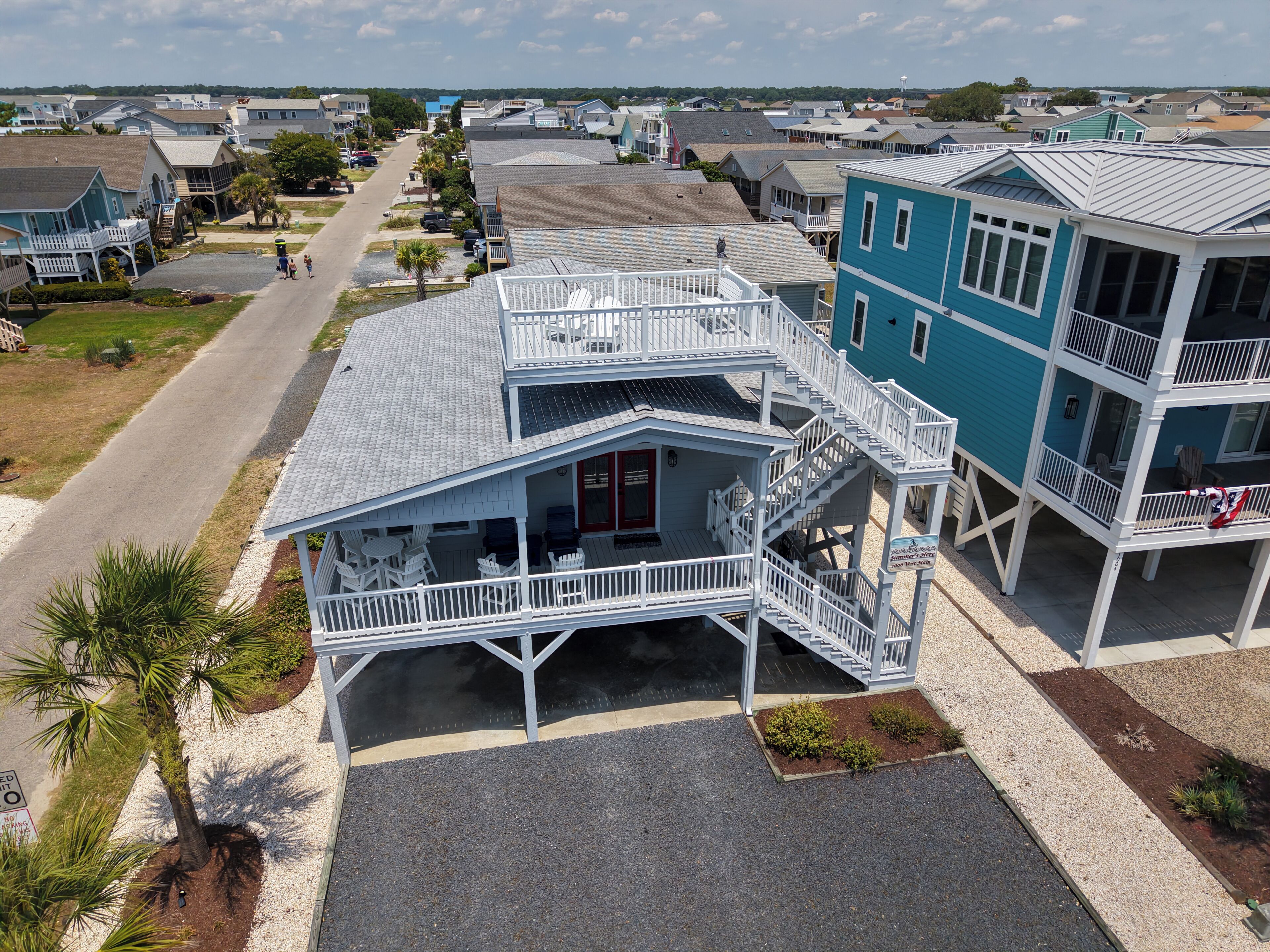 A beachfront property with a two-story building, a covered patio, and a view of the ocean.