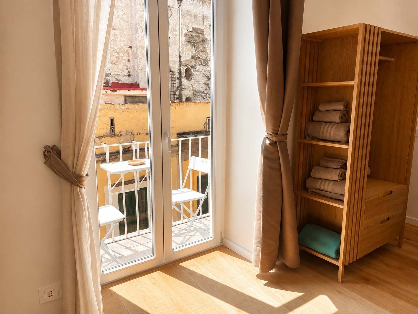 Una habitación con puerta corrediza de vidrio que da a un espacio exterior con una mesa y sillas.
