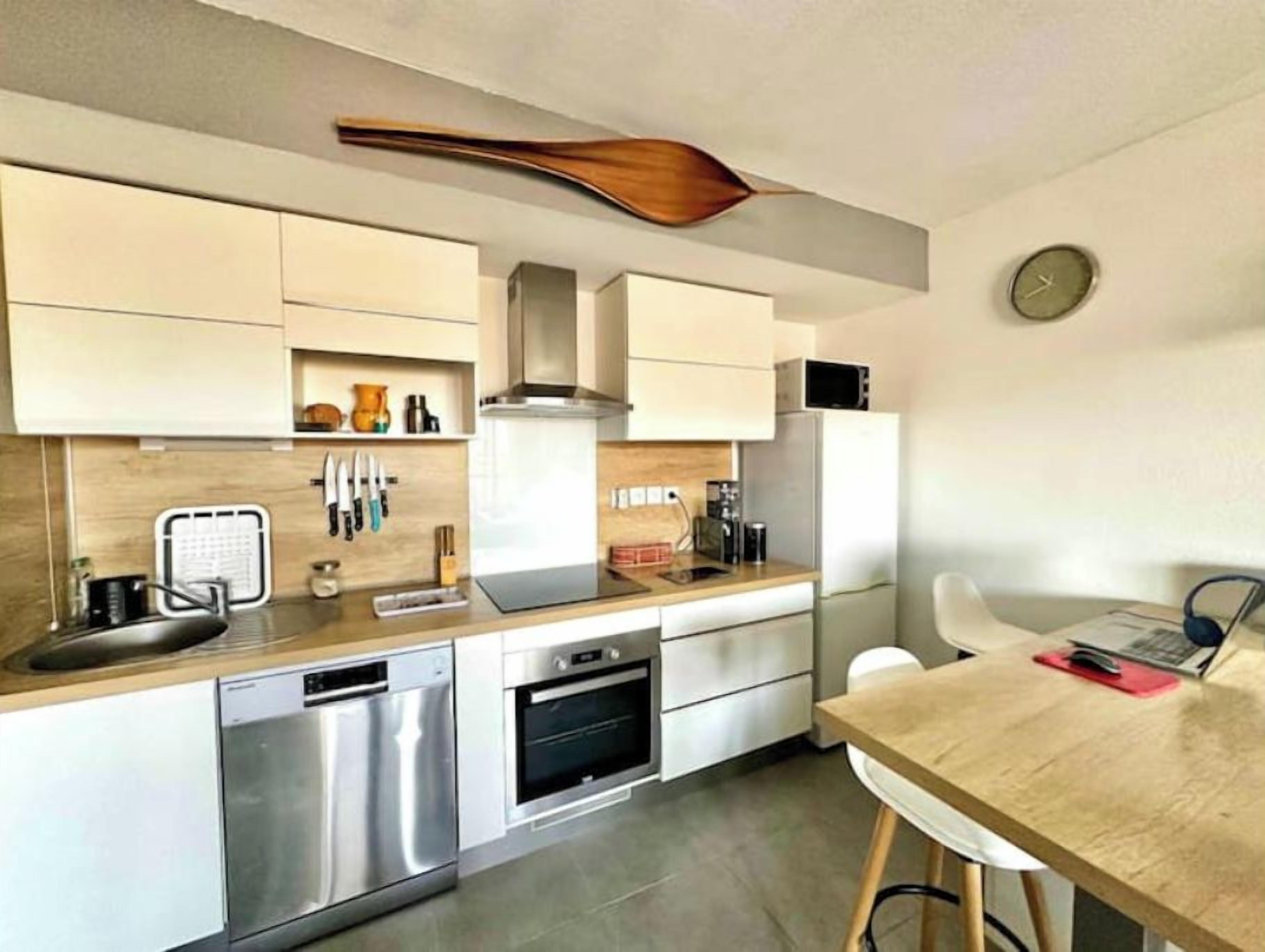 Una cocina moderna con electrodomésticos de acero inoxidable, encimeras de madera y horno empotrado.