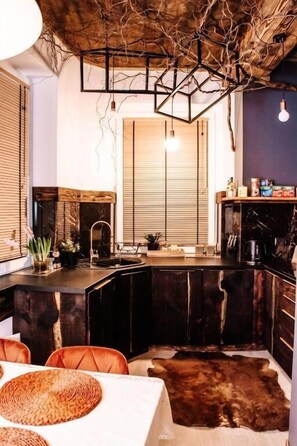 Una cocina moderna con una isla central, armarios de madera y techo rústico.