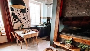 Un intérieur rustique comprenant un coin repas, une table ronde en bois, un tapis en fourrure et une cheminée.