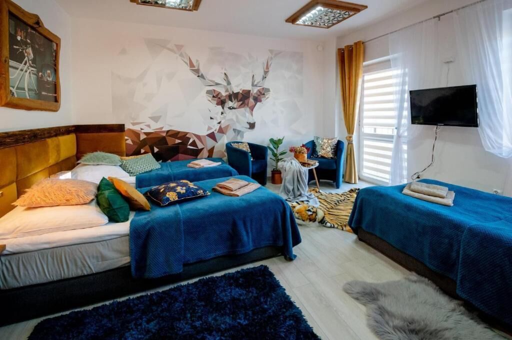 Ein Hotelzimmer mit zwei Betten, einem Fernseher und einem Wandbild.