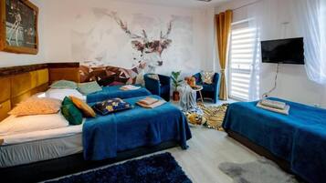 Ein Hotelzimmer mit zwei Betten, einem Fernseher und einem Wandbild.