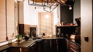 Une cuisine avec un plafond en bois, un tapis en peau de vache et un luminaire suspendu.