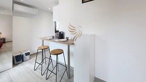 Een moderne keuken met een bar, barkrukken en een logo aan de muur.