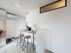 Eine moderne Küche mit Bar, Hockern und einem Logo an der Wand.