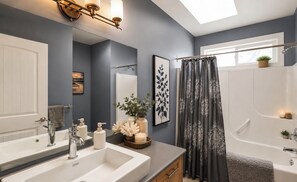 Ein modernes Badezimmer mit Waschbecken, Badewanne und Duschvorhang.