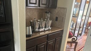A kitchen with dark cabinets, a countertop, and a tiled floor. - Spacious 5-bedroom house in enchanting Austin with AC (Austin)