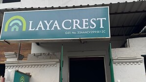 A building entrance with a sign for 'LAYACREST' and a contact number.