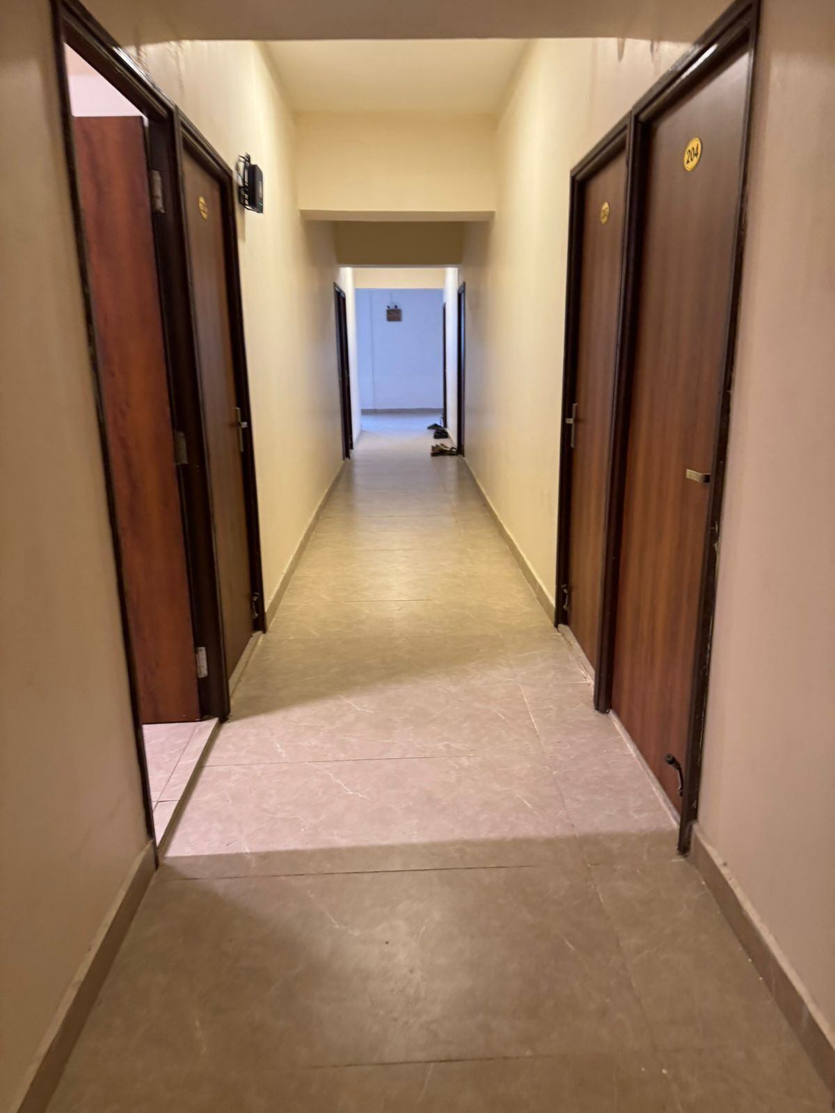 Un pasillo con puertas a ambos lados que conduce a una habitación al final.