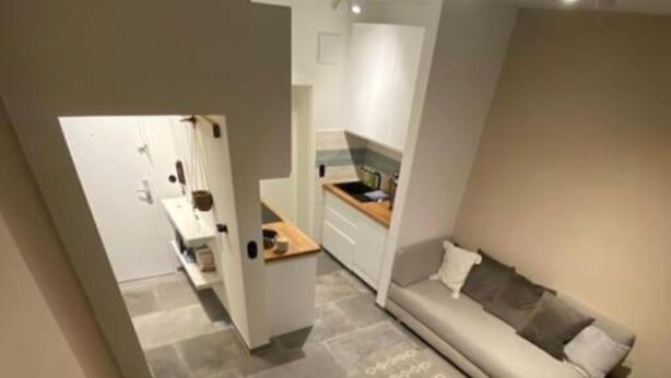 Ett kompakt bostadsutrymme med ett matbord, en soffa och ett köksområde.