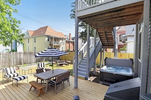 A deck with outdoor furniture, a hot tub, and a staircase leading to a deck. - 4BR Family Retreat | Private Hot Tub + 2 Kitchens (Michigan City)