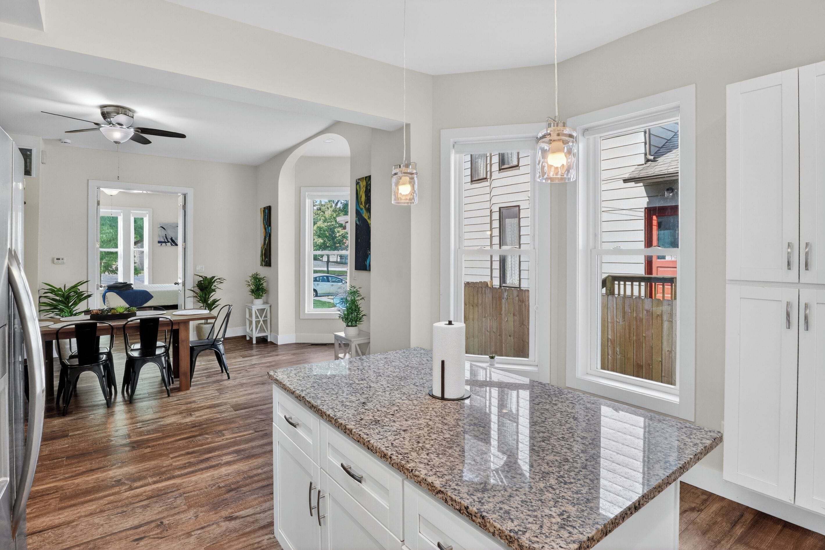 A kitchen with granite countertops, white cabinets, a ceiling fan, and pendant lighting.. Cozy Duplex Retreat | Hot Tub + Full Kitchen