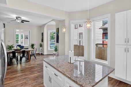 A kitchen with granite countertops, white cabinets, a ceiling fan, and pendant lighting.. Cozy Duplex Retreat | Hot Tub + Full Kitchen