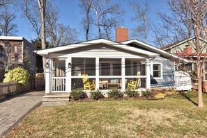 A house with a covered porch, a brick chimney, and a small garden area. - NEW Prime Rehoboth Beach Downtown  5BR Coastal Cottage Walk to Beach & Boardwalk (Rehoboth Beach)