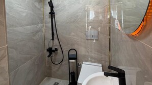 Un baño con ducha, lavabo y espejo.
