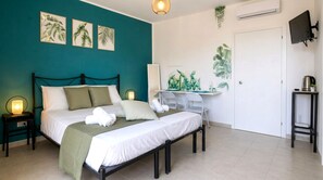 A bedroom with a bed, bedside tables, a desk, a chair, a TV, and a wall-mounted plant. - Concy's Jacuzzi - Private Suite with Sea View and Exclusive Terrace (Kaukana)