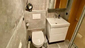 Une salle de bain avec des toilettes, un lavabo et un miroir.