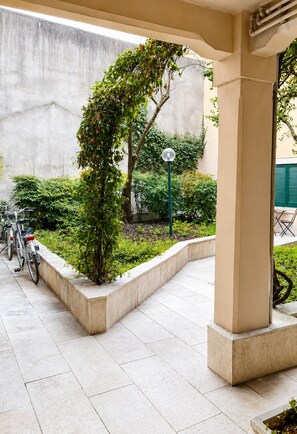 A covered outdoor area with a tiled floor, a bicycle, and a small tree. - San Zeno Charm ♡ Walk to Verona's City Center ♡ A/C & Parking (Verona)