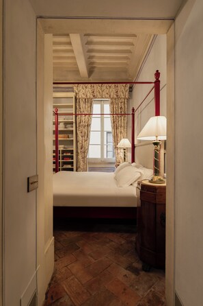 A bedroom with a bed, bedside lamps, a wooden nightstand, a wardrobe, and a window with curtains. - Guelfa 19 - (3) - One Bedroom Apartment, Sleeps 3 (Cortona)