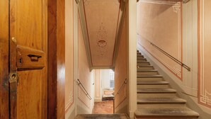 Eine Treppe mit Geländer und einer Holztür links.