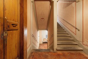 Eine Treppe mit Geländer und einer Holztür links.