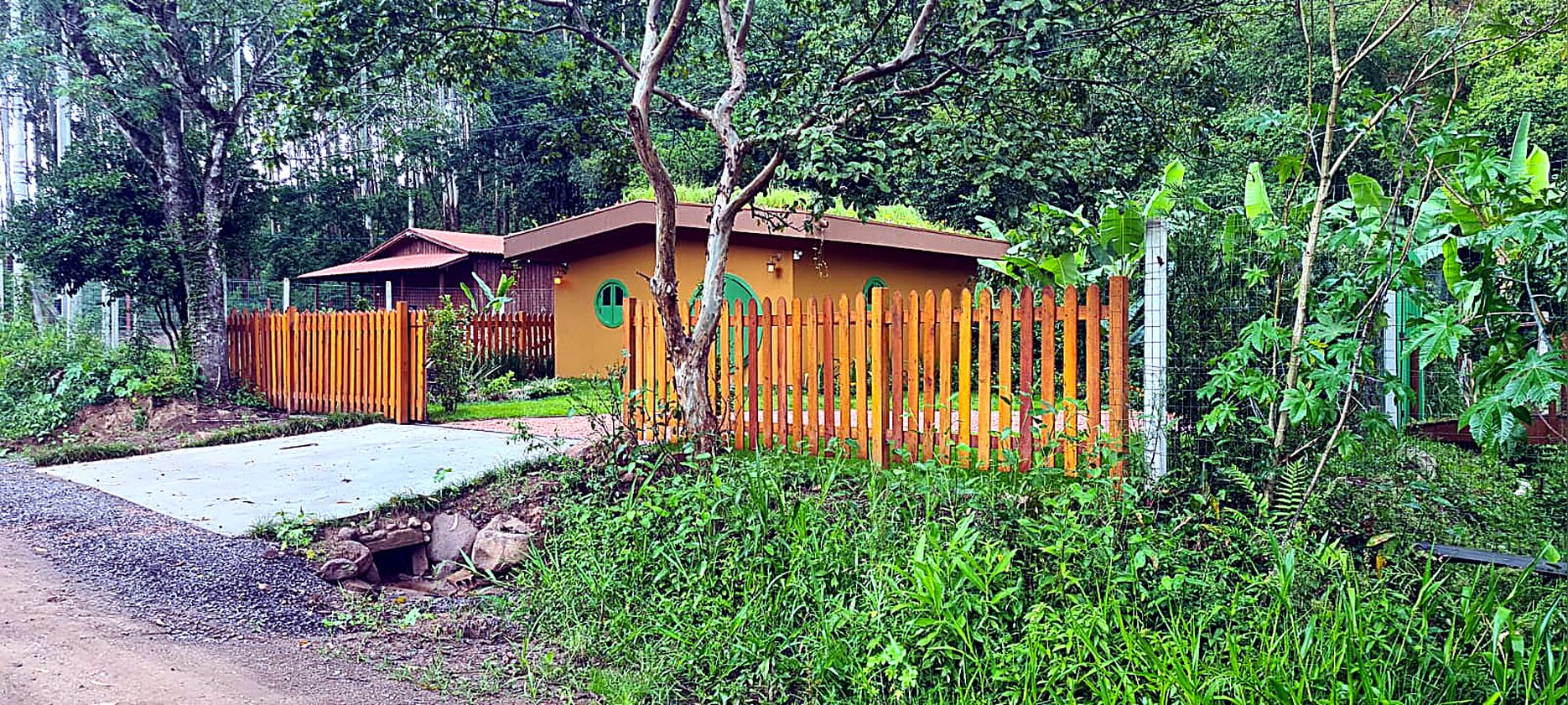 A single-story building with a brown roof and a fenced yard.
