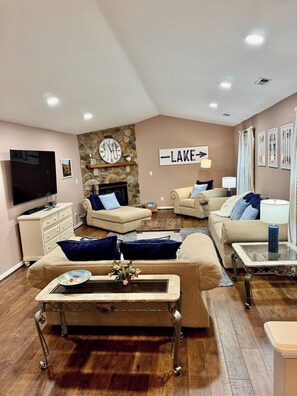 Ein Wohnzimmer mit Steinsturz, Fernseher, Kamin und einem Schild mit der Aufschrift 'LAKE'.
