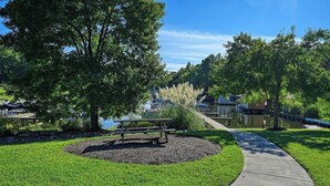 A park with a picnic table, a walking path, and a body of water in the background. - Rockland Creek Retreat at LKA with Water Access (Bumpass)