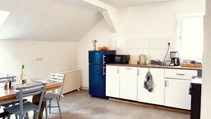 A compact kitchen with a refrigerator, microwave, and coffee maker.